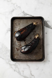 Oven-Roasted (broiled) eggplants with charred skin in a bowl