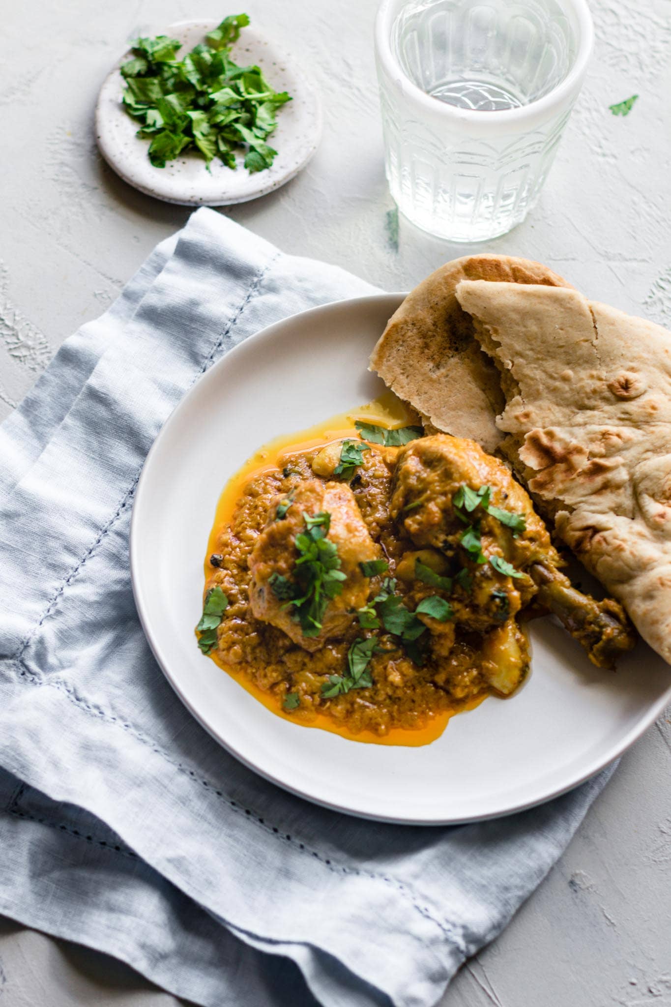 Chicken Korma on a white plate with naan