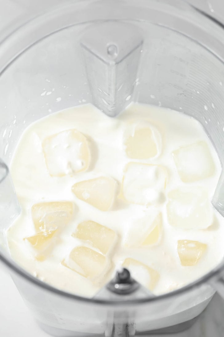 Milk, whipping cream, yogurt, ice, and sugar added in a blender.