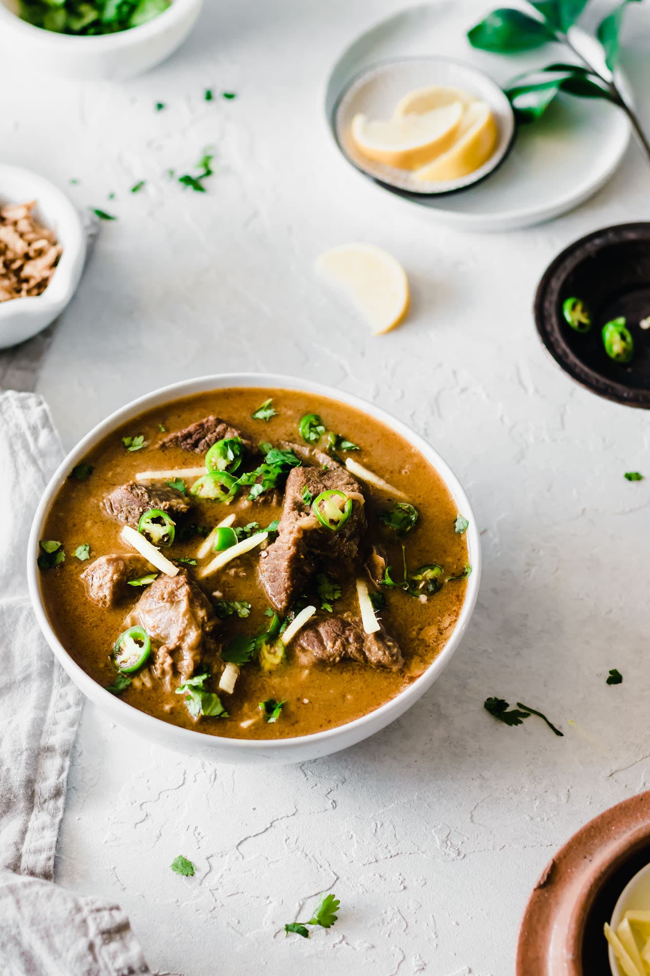 A bowl of Instant Post Nihari garnished with cilantro, green chilies and ginger.