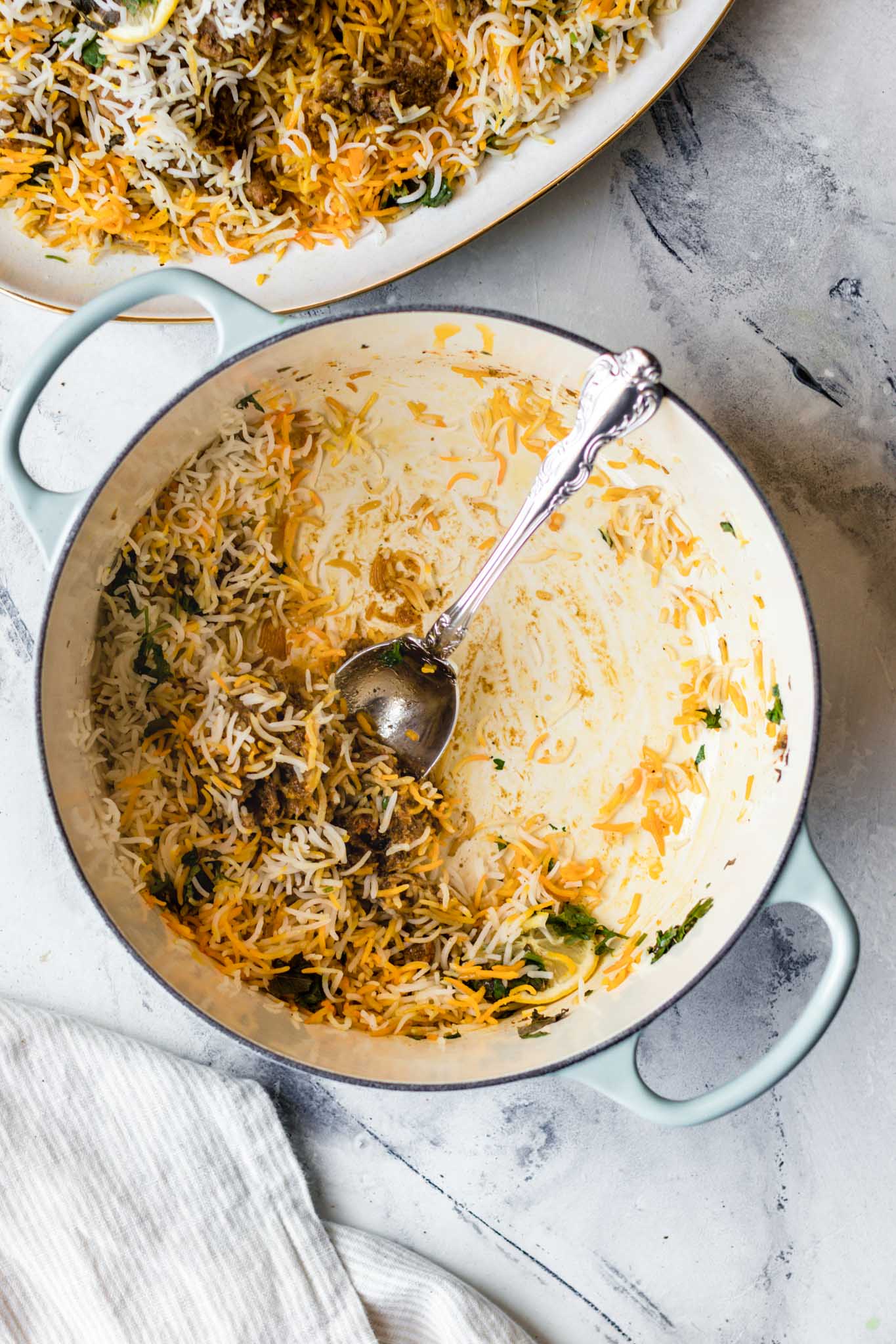 Chicken Biryani scooped out with a silver spoon from a cast iron dutch oven