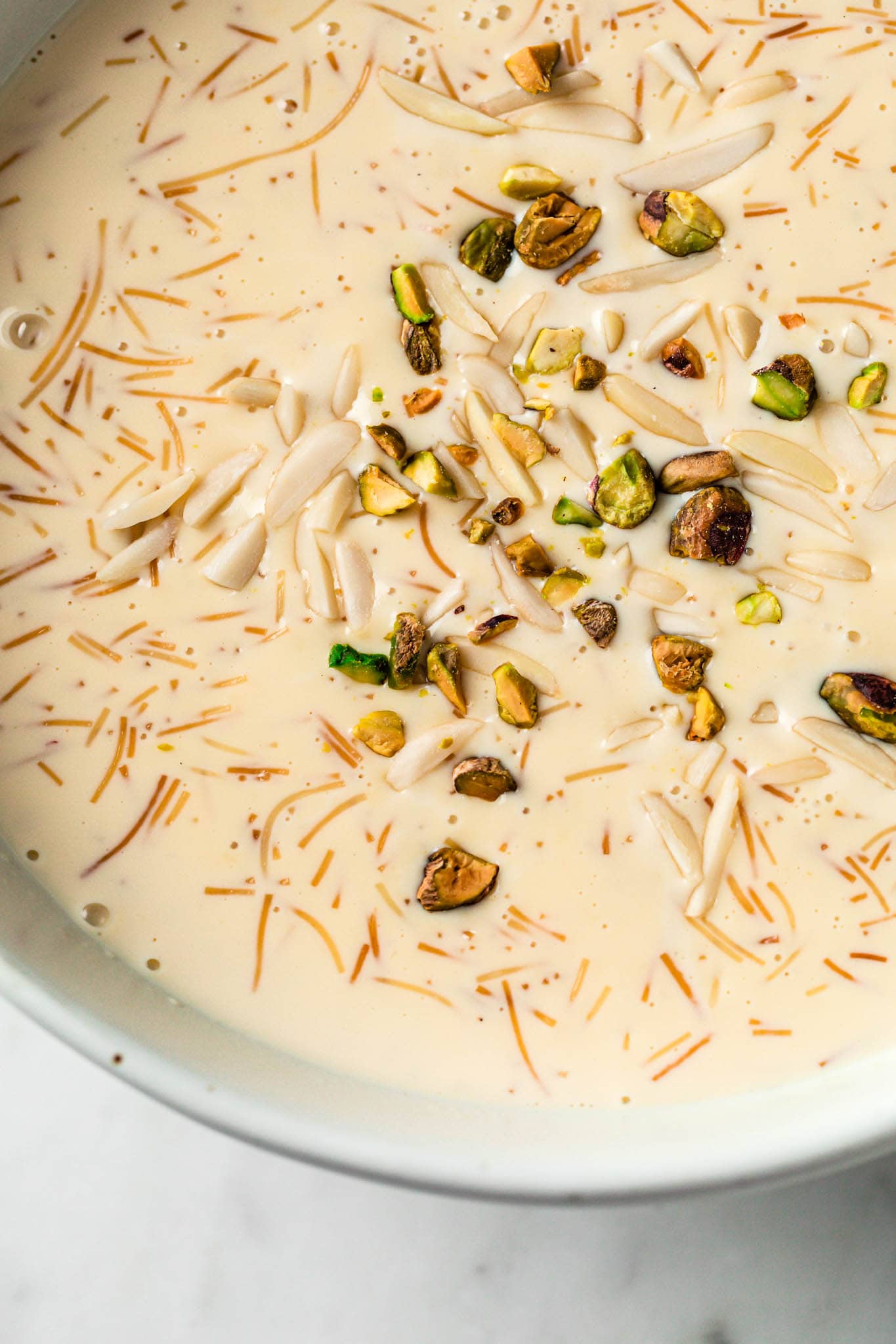 A close up of creamy seviyan garnished with nuts