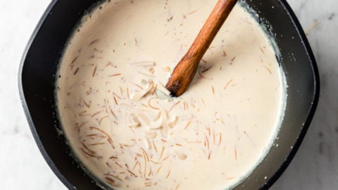 A large saucepan with creamy vermicelli garnished with slivered, blanched almonds