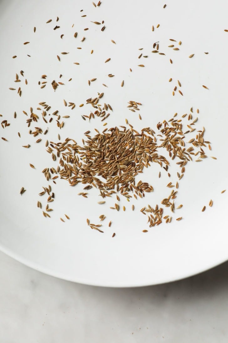 Toasted cumin seeds in a white skillet
