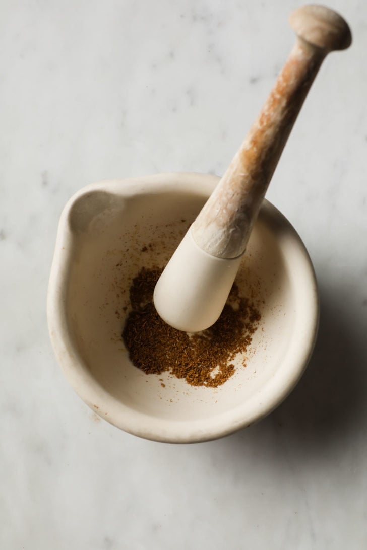 Ground cumin seeds in a mortar and pestle