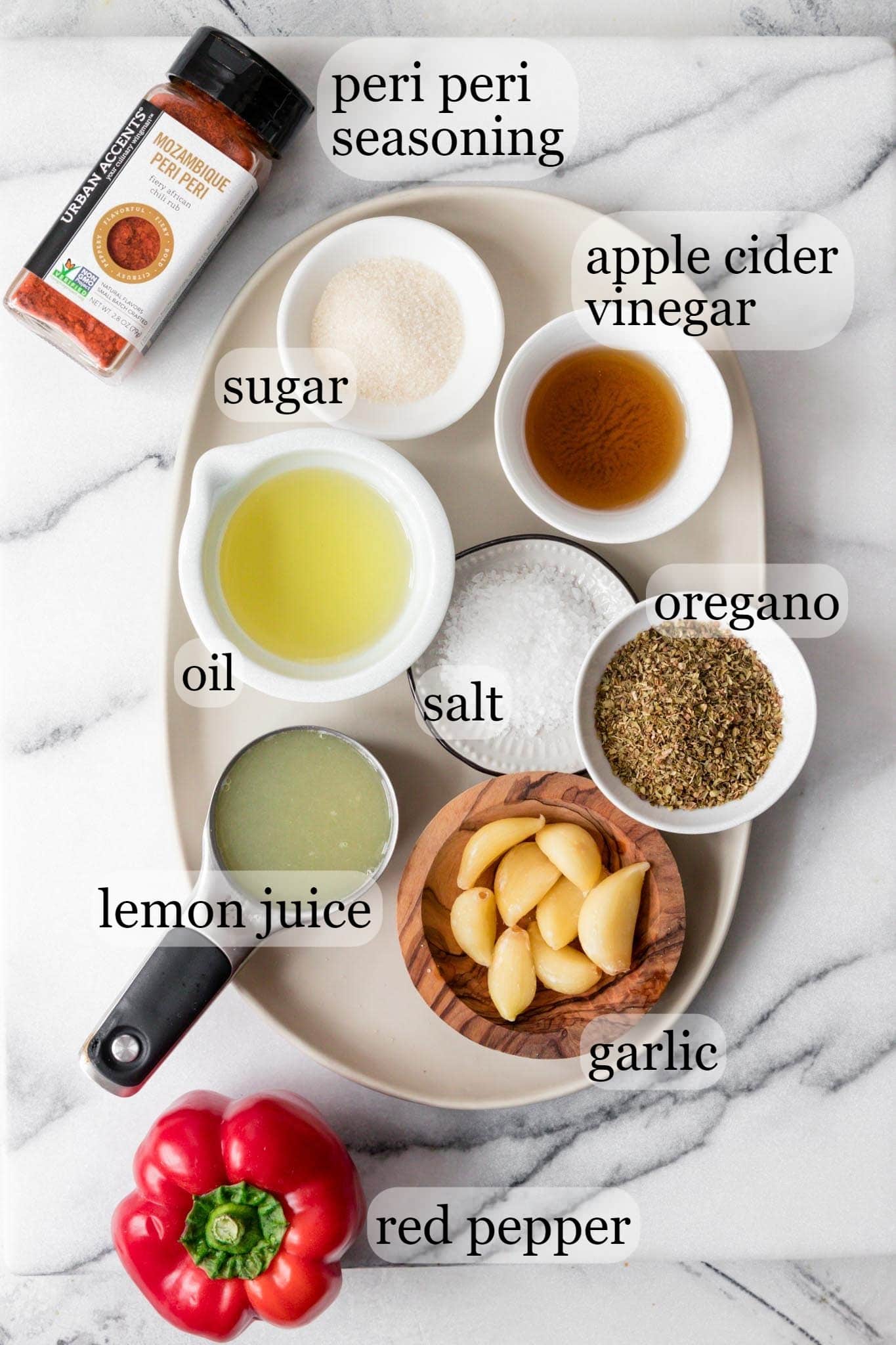 Ingredients for Peri Peri Sauce including peri peri seasoning, sugar, apple cider vinegar, oil, salt, oregano, lemon juice, garlic and red pepper.