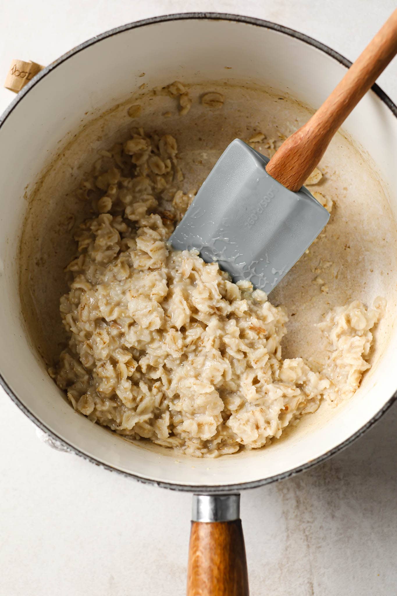 Oatmeal cooked down in a white saucepan