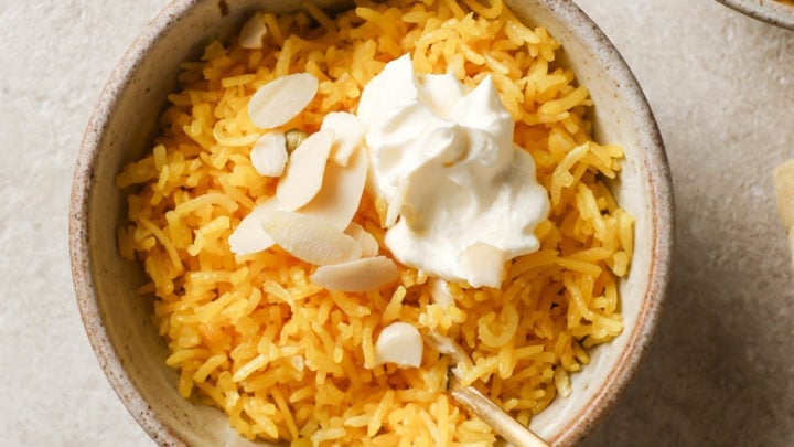 A bowl of Zarda ready to be eaten with a spoon.