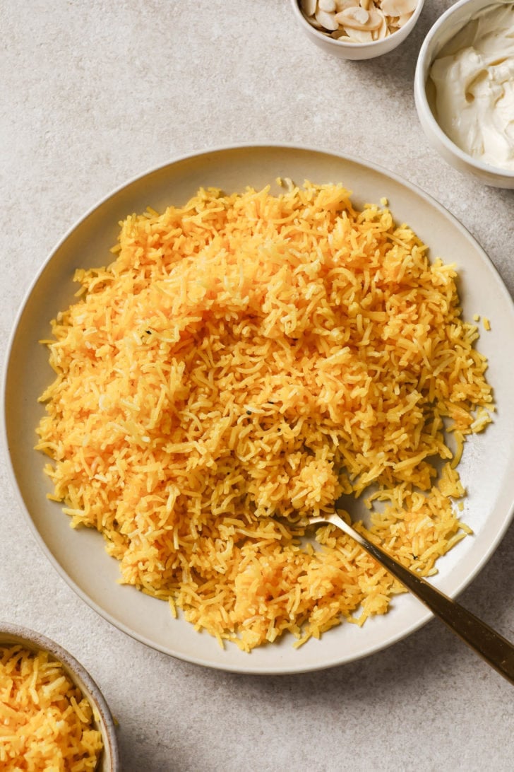 Zarda (Meethe Chawal) in a large plate with malai and nuts on the side.