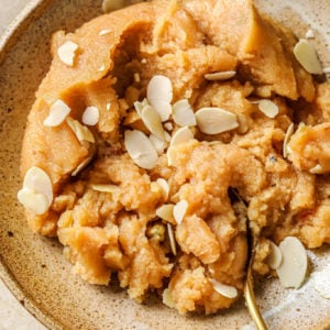 Sooji ka Halwa in a bowl garnished with blanched, slivered almonds.