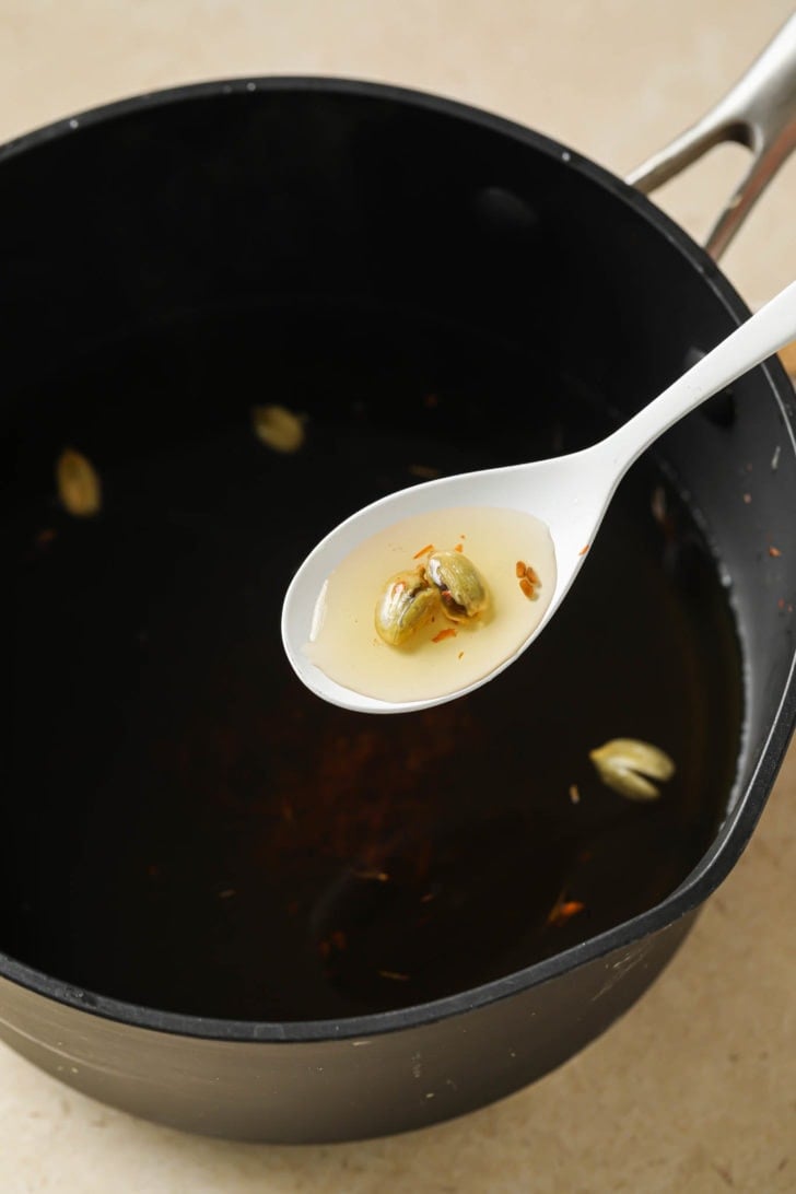 Sugar syrup with cardamom and saffron in a saucepan.