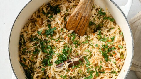 Cooked Matar Pulao in a dutch oven garnished with cilantro.