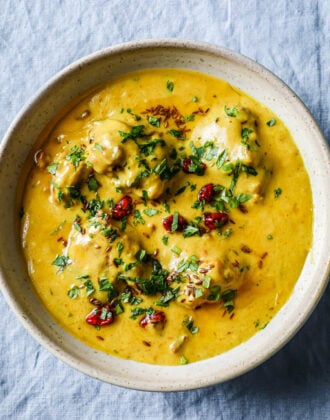 Kadhi Pakora in a bowl garnished with cilantro and whole red chili.