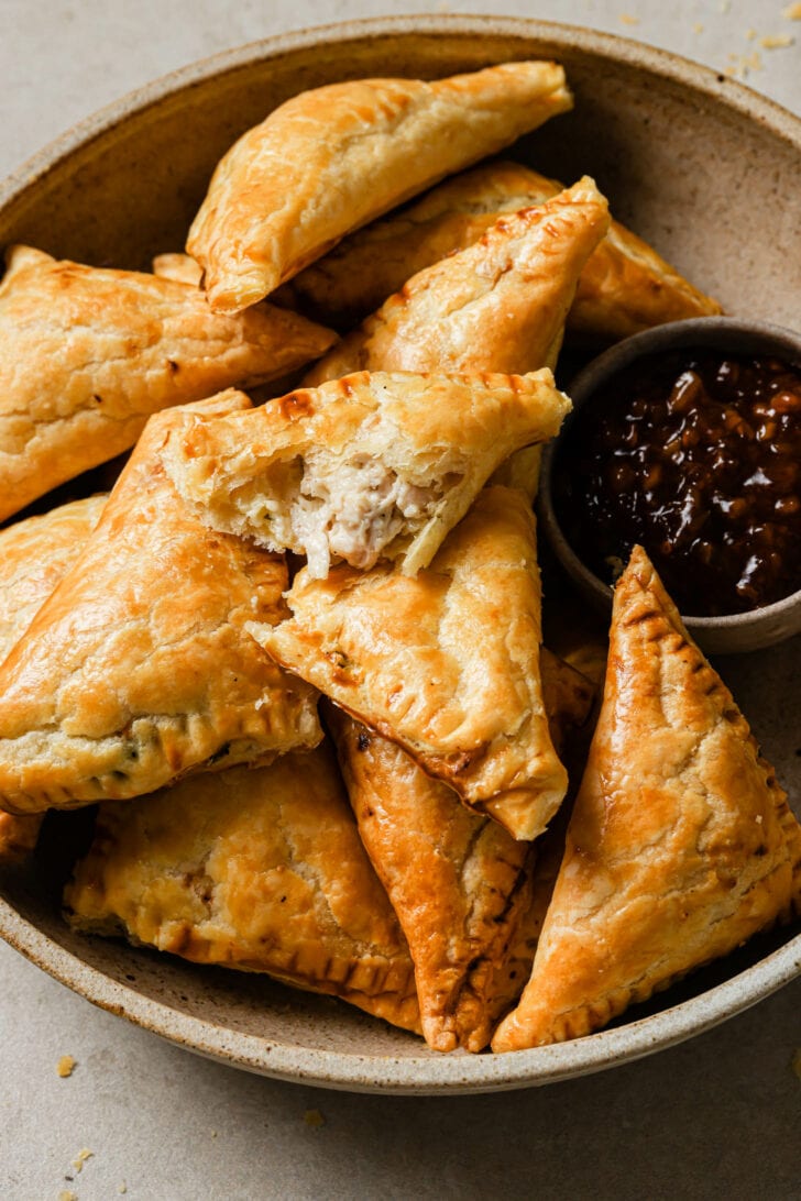 A bowl of Chicken Puff Pastries with tamarind chutney.