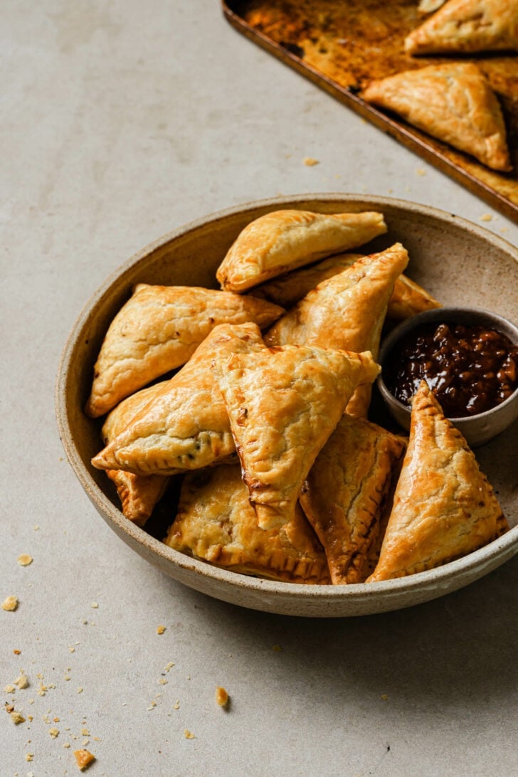 A bowl of Chicken Puff Pastries with tamarind chutney.