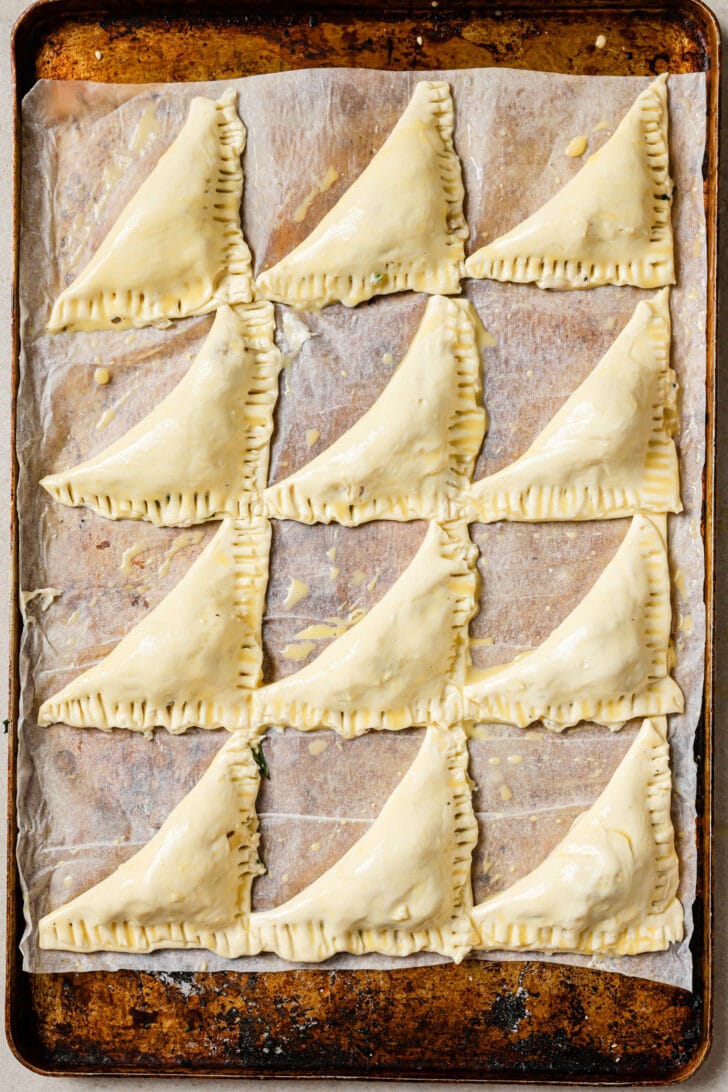 Uncooked Chicken Puff Pastries on a baking sheet.