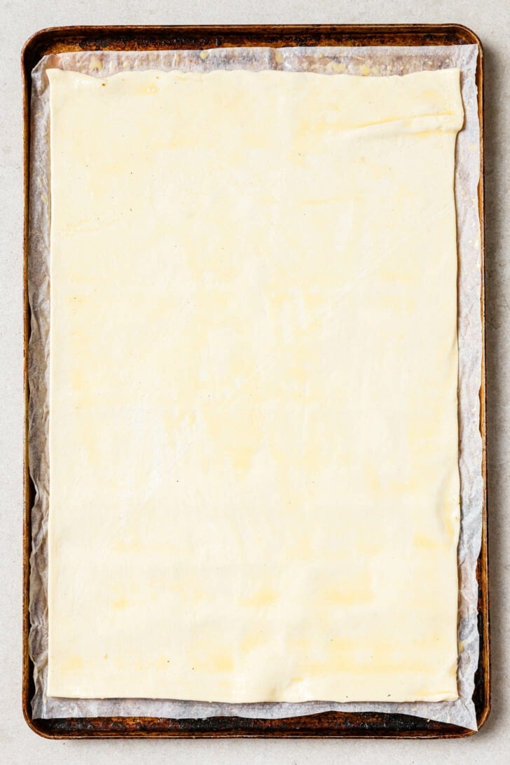 Uncooked puff pastry on a baking sheet.