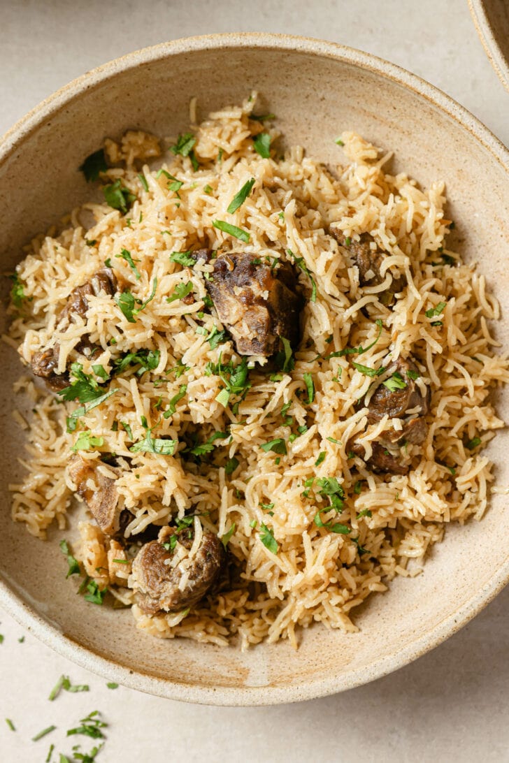 A bowl of Mutton Pulao garnished with cilantro.