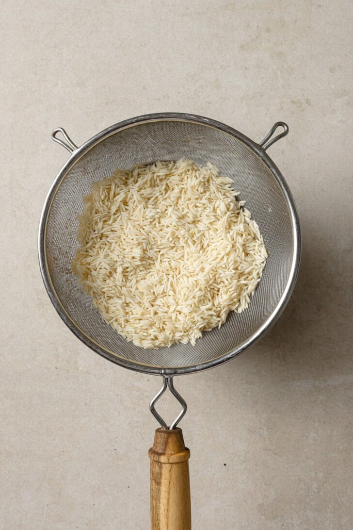 Drained rice in a strainer.