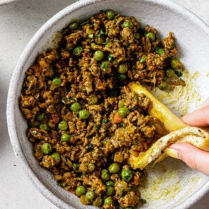 Scooping up Keema Matar with a piece of naan.