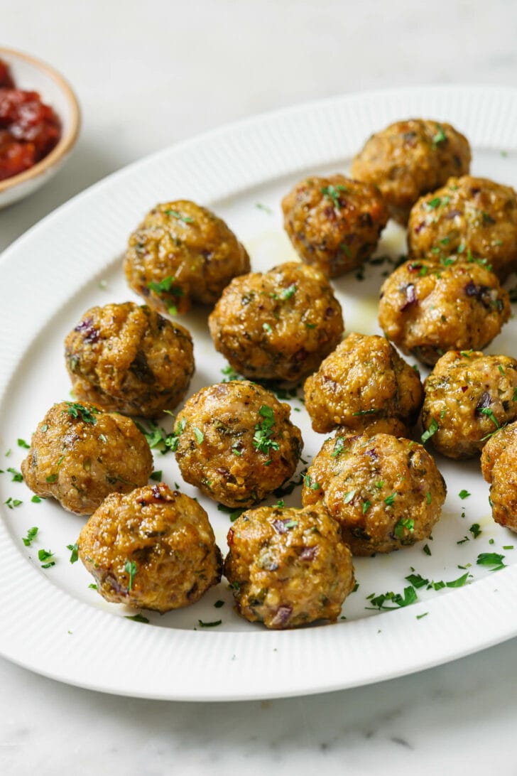 A platter with Baked Chicken Kofta garnished with chopped cilantro.