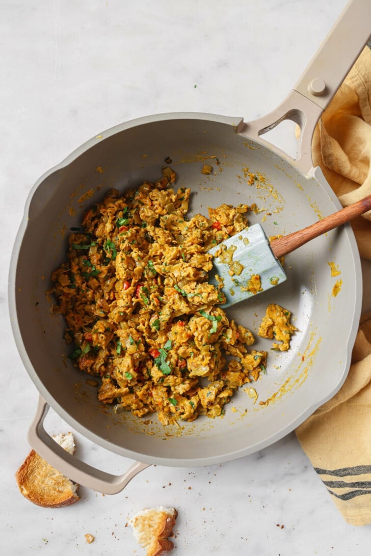 Top view of a skillet of Egg Bhurji with a rubber spatula.