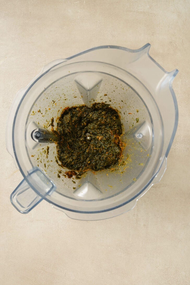 Blended spinach and tomato mixture in a blender to make Palak Paneer.