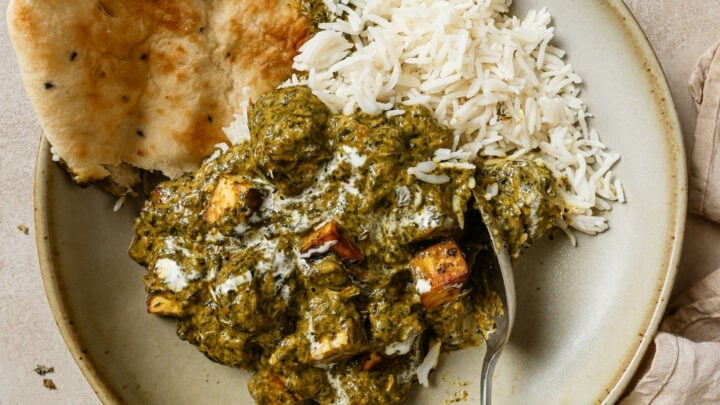 Palak Paneer in a bowl with naan and rice, ready to be eaten