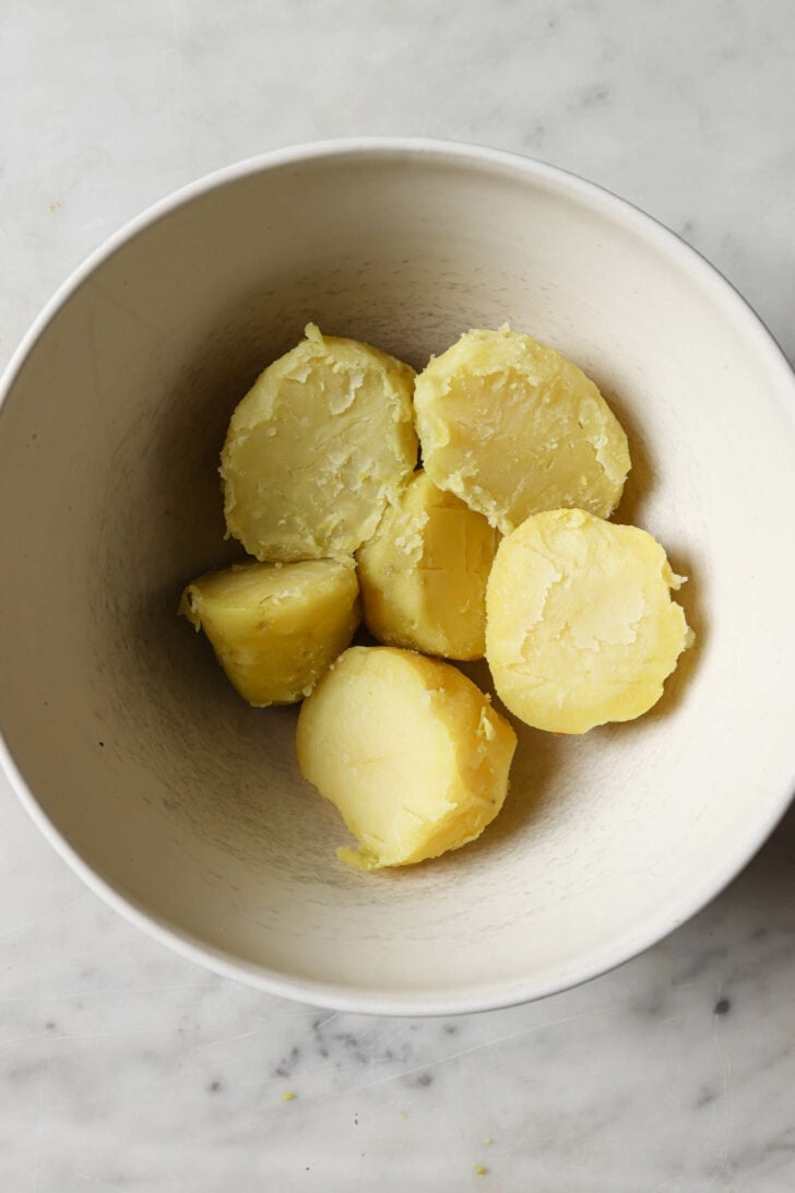 Peeled and cooked potatoes in a bowl.