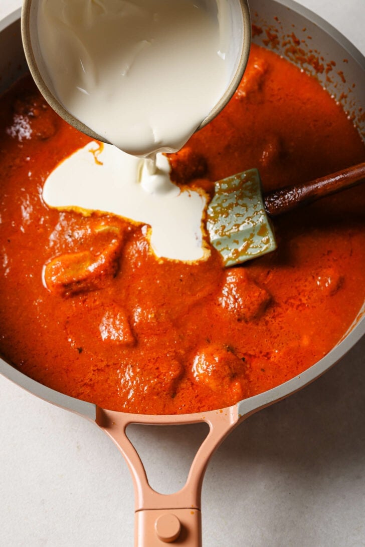 Pouring cream into Butter Chicken.