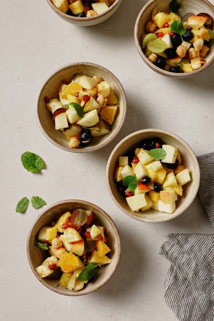 Fruit Chaat in small bowls garnished with mint leaves.