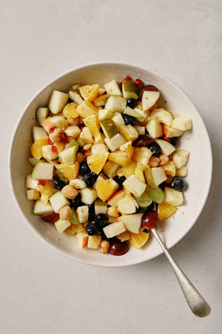 Fruit Chaat in a bowl with a spoon.